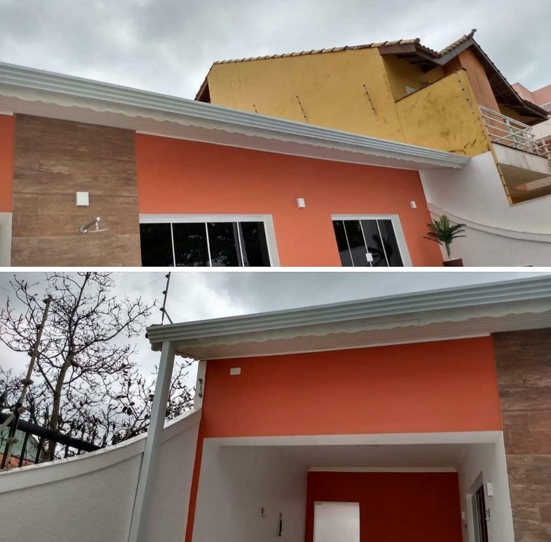 Calha branca contornando o beiral de uma casa com fachada laranja