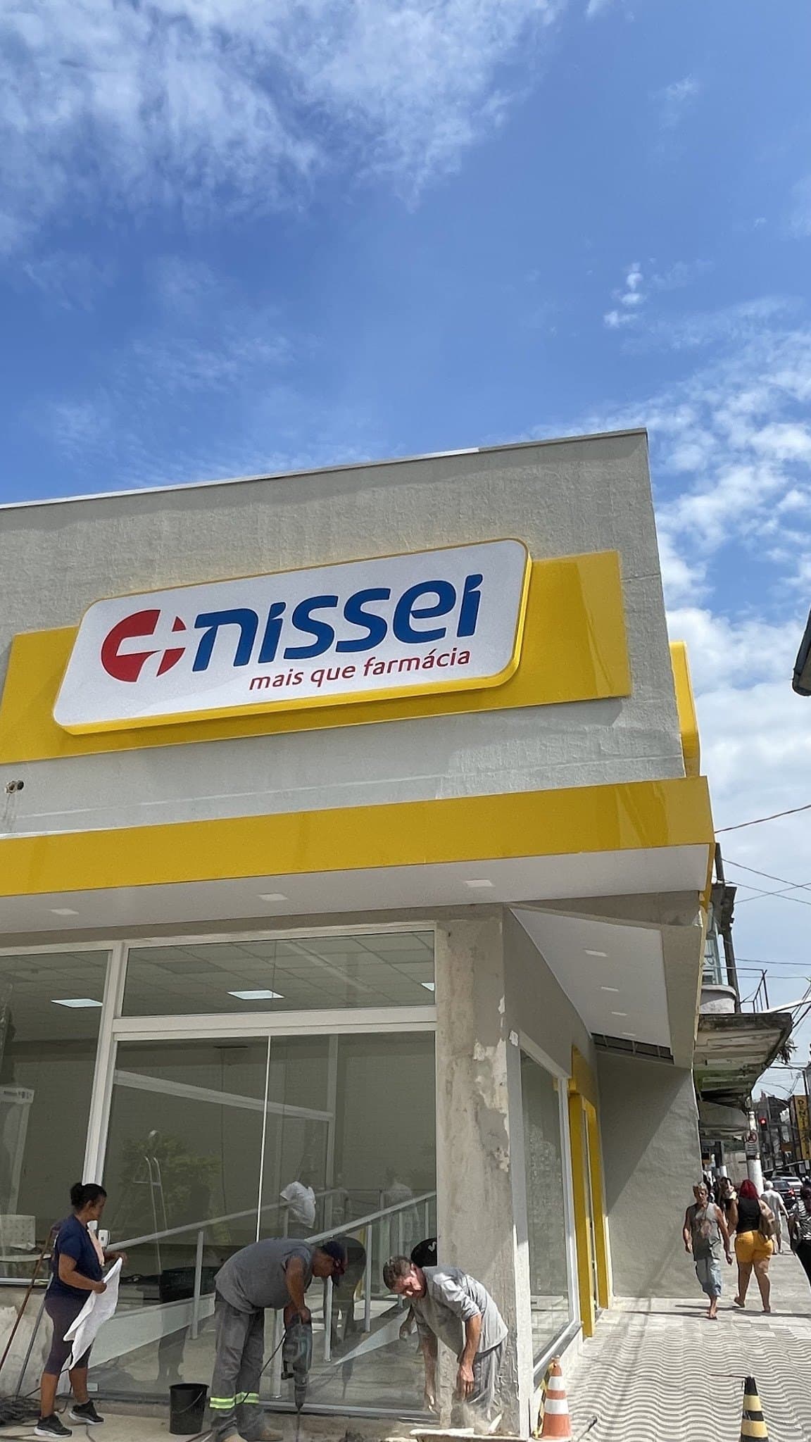 Equipe instalando calhas na fachada de uma farmácia recém-construída