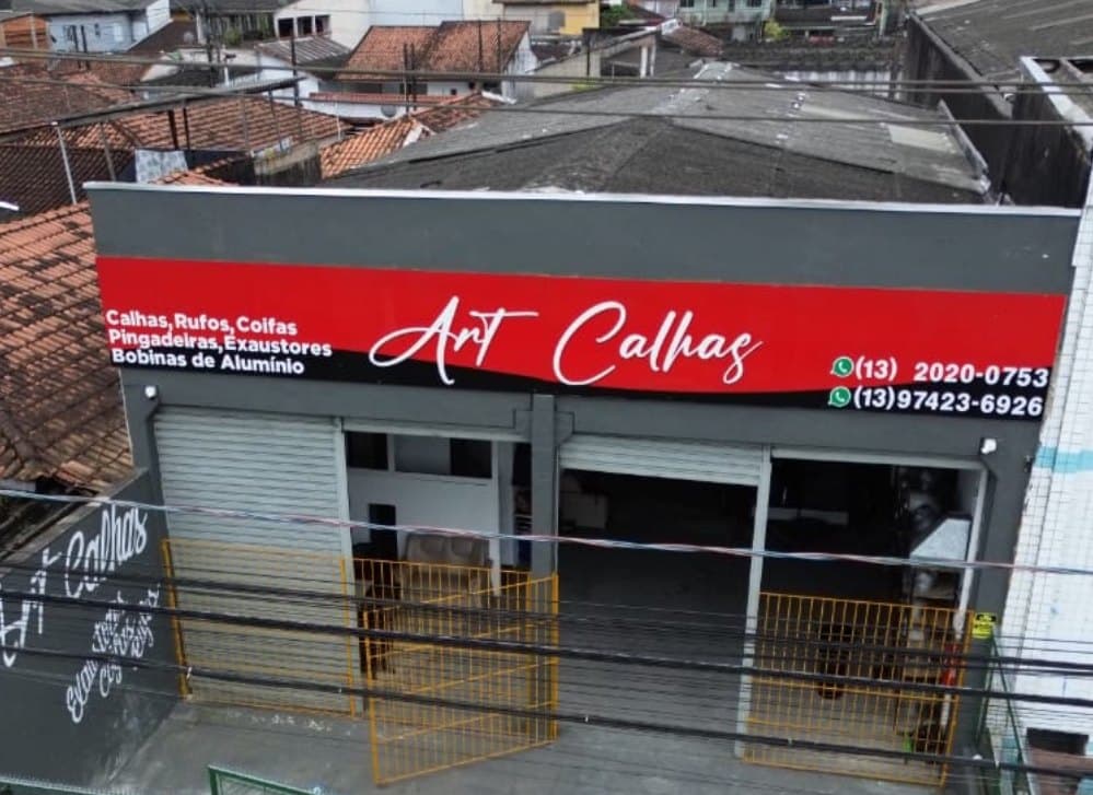 Vista do alto da loja Art Calhas, com o letreiro 'Calhas, Rufos, Coifas, Pingadeiras, Exaustores, Bobinas de Alumínio'