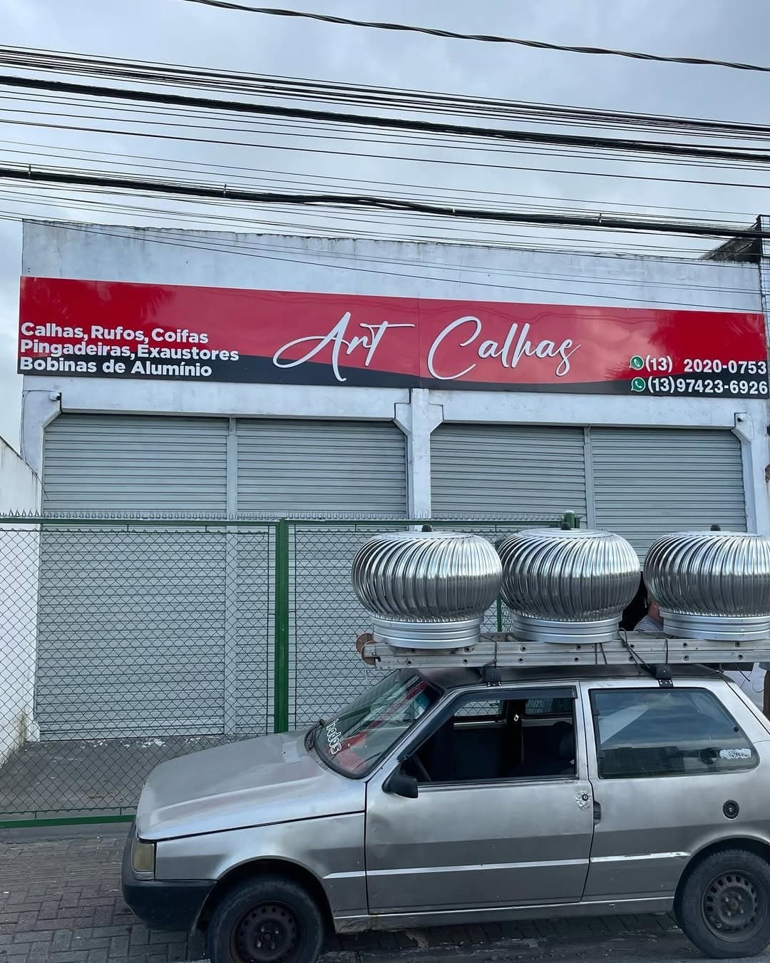 Exaustores eólicos amarrados no rack de um carro em frente à loja, prontos para entrega