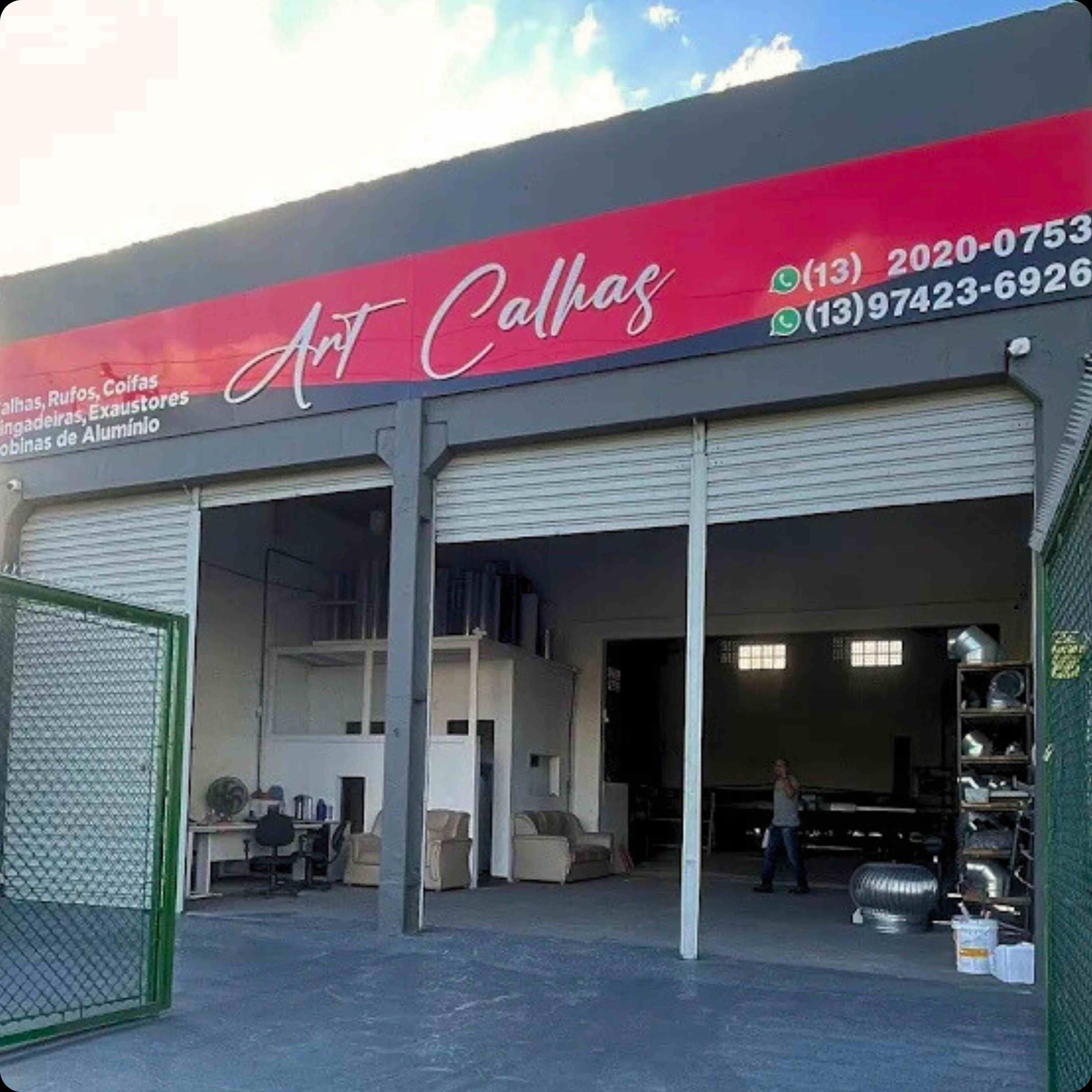 Fachada da loja Art Calhas com as portas abertas e o letreiro vermelho com os telefones