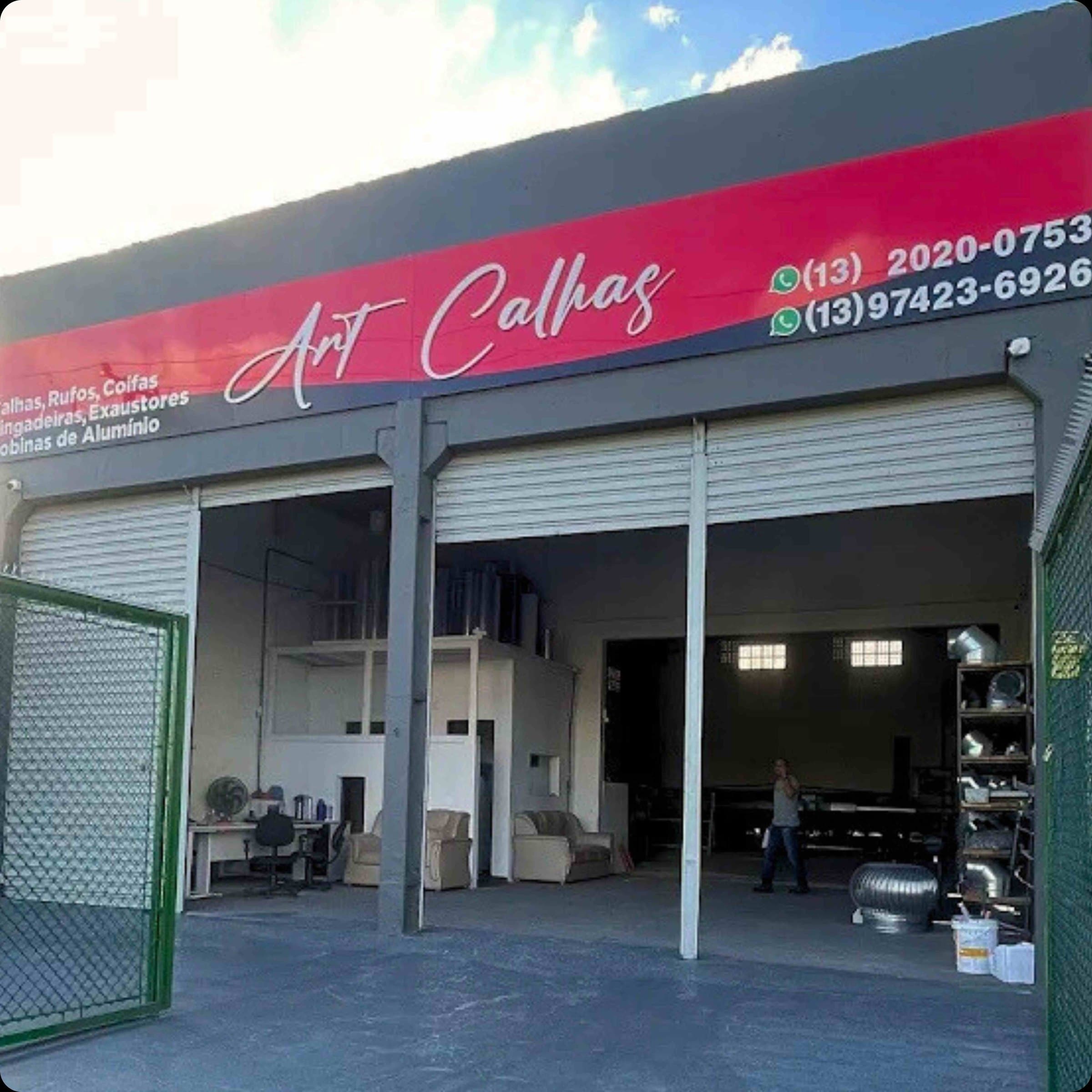 Fachada da loja Art Calhas com as portas abertas e o letreiro vermelho com os telefones