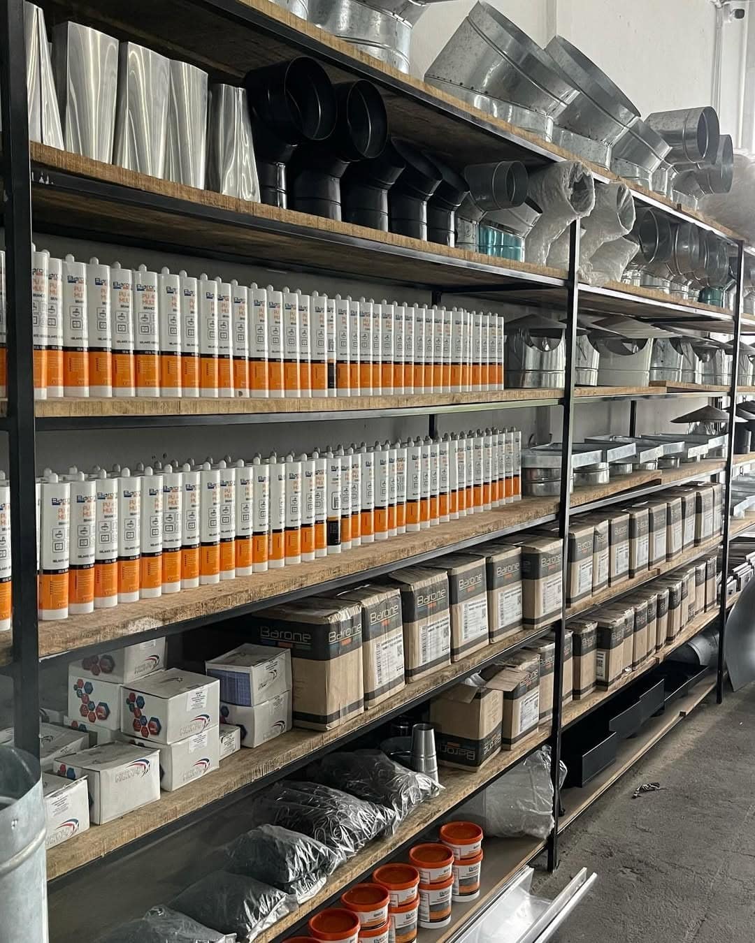 Prateleiras da loja com conexões, dutos, selantes e acessórios para calhas